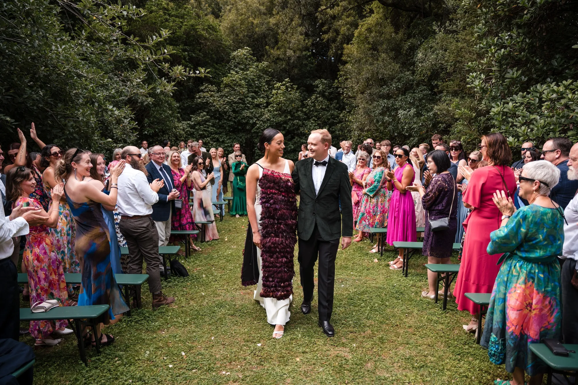 Bride and groom walking down the aisle past their guests